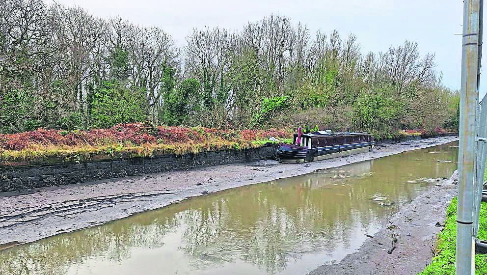 A stranded narrowboat sits on mud after water drained from the Bridgewater Canal following the breach. PHOTO: TAYLORS ABOARD