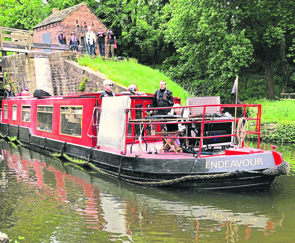 Musician Steve Varden on board Richard’s Endeavour with the charity boat’s volunteers at Bingley’s Five Rise Locks. PHOTO: SALLY CLIFFORD