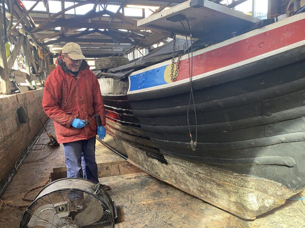 Another team volunteer blacking Kilsby at Tooley’s Boatyard.