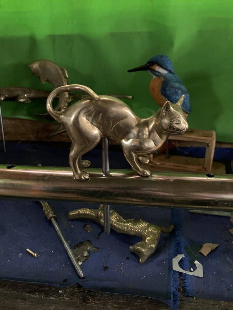 A resin kingfisher tiller pin and a brass cat in the foreground. PHOTO: NICK TAIT