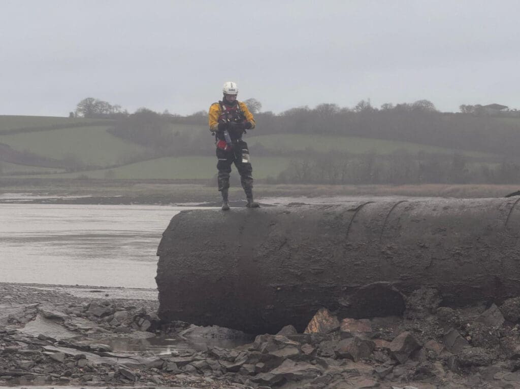 A lifeboat station crew volunteer stands on one of the toppled bridge pillars. SARA